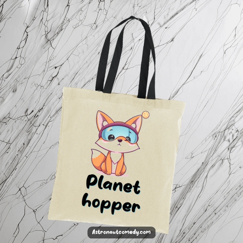 Funny tote bag showcasing a cheerful fox wearing a visor, looking out at a distant planet in space.